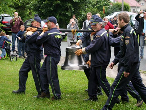 hasiči odnáší zvon k lešení vedle zvonice (rok 2011)